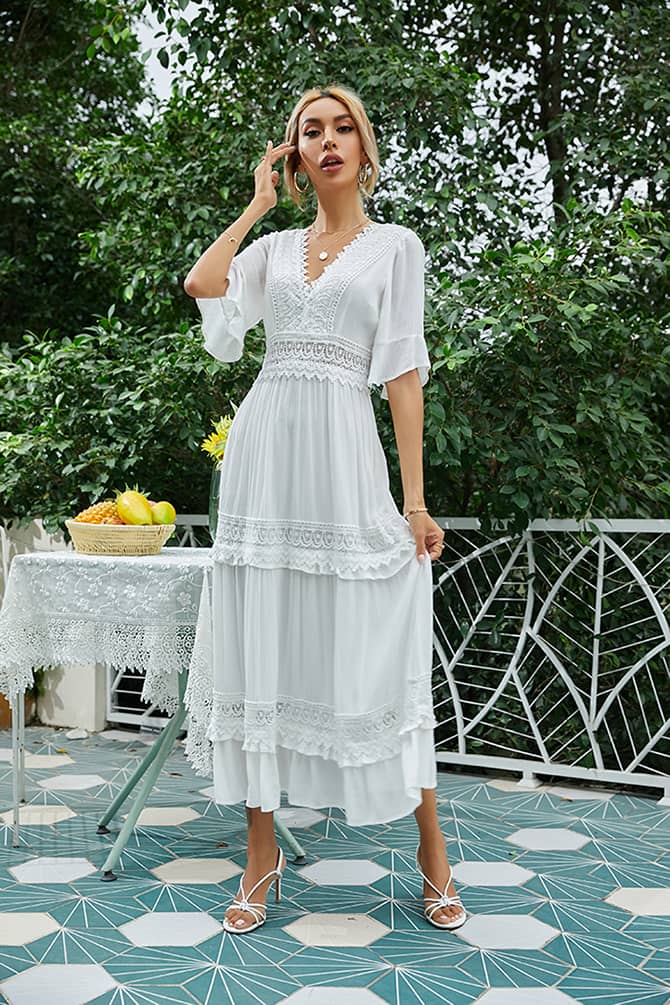Woman in a light blue pleated wrap dress perfect for a wedding guest.