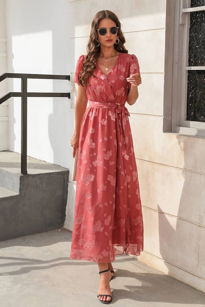 Woman in a long red floral print dress, an elegant wedding guest choice.