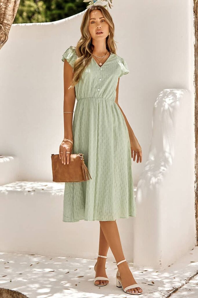A woman wearing a sage green midi dress, embodying the casual yet stylish essence of Dress Aussie Style for a summer wedding.